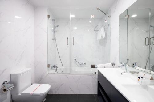 法蒂玛法蒂玛酒店的白色的浴室设有浴缸、卫生间和水槽。