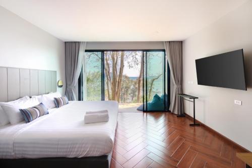 奈汉海滩Nature Vista Rawai的一间卧室配有一张大床和一台平面电视