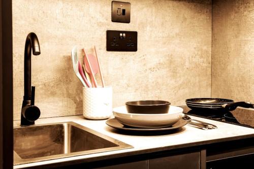 莱斯特Superior 1 Bed Studio 3D near Royal Infirmary & DMU的厨房配有水槽和2个平底锅及餐具