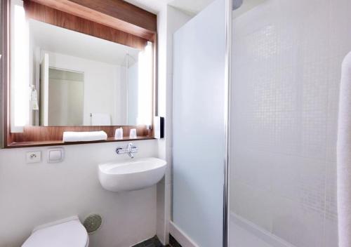 塞克兰里尔瑟克朗钟楼酒店的一间带卫生间、水槽和镜子的浴室