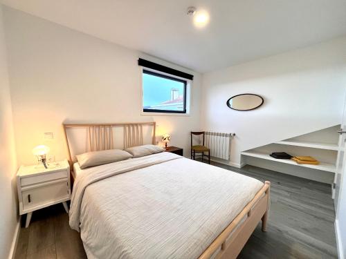 埃斯波森迪Hostel do Alto - Fão的一间卧室设有一张大床和一个窗户。