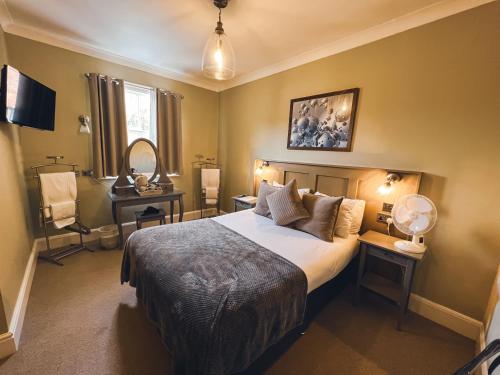 史云顿The Kings Arms的一间卧室配有一张大床和两张带台灯的桌子。