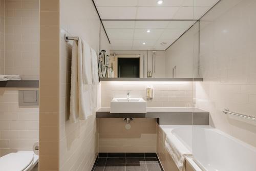 海牙巴比伦海牙酒店 的一间带水槽、浴缸和卫生间的浴室