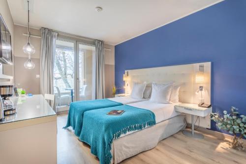马赛Zenitude Hôtel Résidences Marseille Saint-Charles的一间卧室设有一张蓝色墙壁的大床