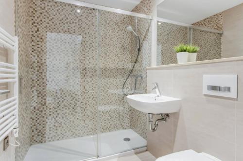 直布罗陀West One Studio Apartments的带淋浴、卫生间和盥洗盆的浴室