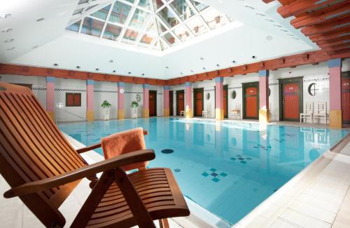 鲁哈科维斯约尔科威科夫酒店的一座建筑中间的带摇椅的游泳池