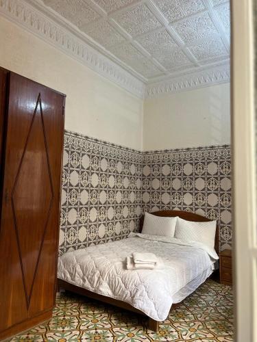 拉巴特Riad Blue Garden的卧室配有一张床铺,位于带墙壁的房间