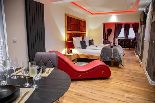 吉夫霍恩exkl. romantisches SM Apartment Black Rose的酒店客房,配有一张床和一张红色椅子