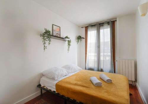贝宗Le CENTRE VILLE de Bezons的一间卧室配有一张床,上面有两条毛巾