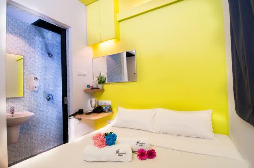 新加坡Fragrance Hotel - Classic的一间卧室设有黄色的墙壁、一张床和一个水槽