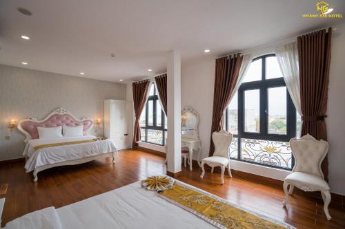 绥和市Hoàng Gia Hotel Tuy Hoà的一间设有床铺和2个窗户的大卧室