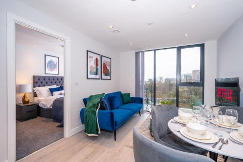 曼彻斯特City Cosy 1 bed - Perfect for Long Stays By Valore Property Services的客厅配有蓝色的沙发和桌子