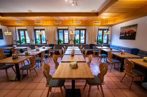 安纳贝格-伦格茨达赫斯坦西运动酒店的餐厅设有木桌、椅子和窗户。