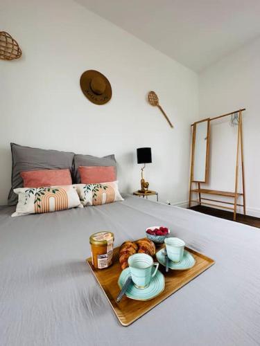 圣布里厄La dolce Vita/maison/5km plages的床上的茶杯和羊角面包托盘