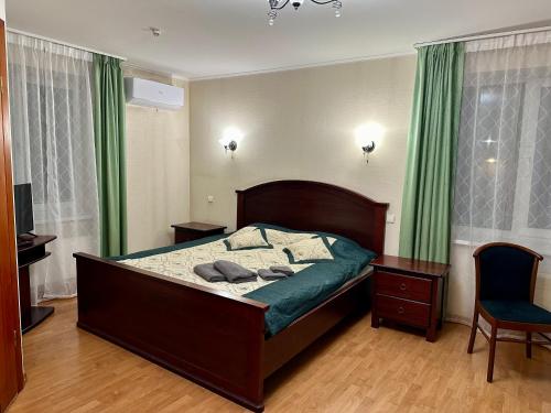 陶格夫匹尔斯二重奏的一间卧室配有一张带绿色窗帘的床和一把椅子