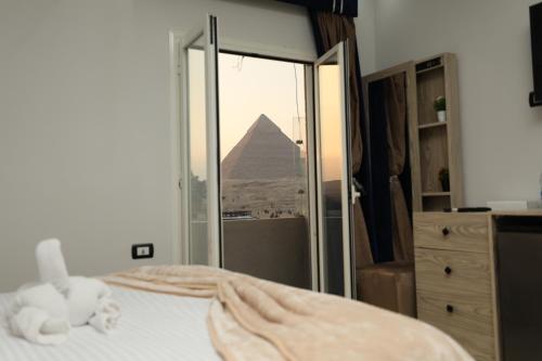开罗Capital Of Pyramids Hotel的一间卧室配有一张床,享有金字塔的景色