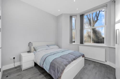 伦敦Your Cosy Stay Modern 3 Double Bedroom Apartment - Fully Furnished - 5 Mins walk to Stn的白色的卧室设有床和窗户