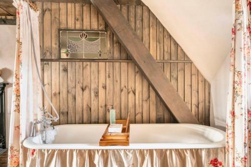 邓甘嫩Rosehill House的木墙客房内的浴缸