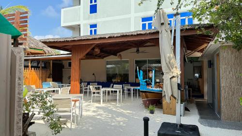 费利杜Alimas Holiday Retreat Maldives的一个带遮阳伞和桌椅的庭院。