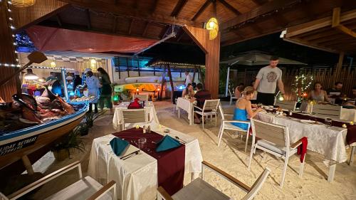 费利杜Alimas Holiday Retreat Maldives的一群坐在餐厅桌子上的人