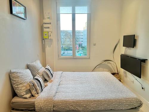 维勒班Gaby, cosy & cocooning, idéal pour 2pers的一间卧室配有一张床、一张沙发和一个窗口
