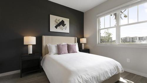 Fort Myers VillasLanding Modern Apartment with Amazing Amenities (ID8608X81)的卧室配有白色床、两盏灯和一扇窗户。