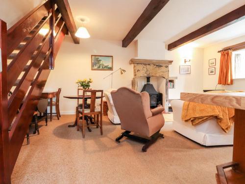 哈利法克斯Boothsteads Farm Cottage的客厅设有楼梯、椅子和壁炉