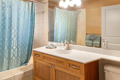 基黑Lotus Suite in a Boutique Resort, 1Bedroom Sleeps 4的浴室设有水槽和蓝色的浴帘