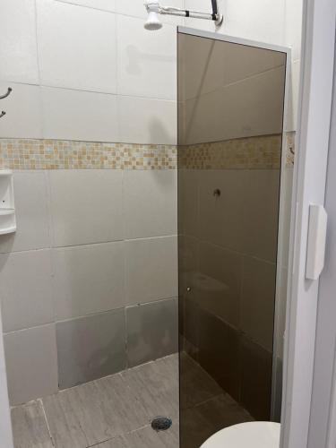 瓜鲁雅Pousada Suítes Sete Mares的浴室里设有玻璃门淋浴