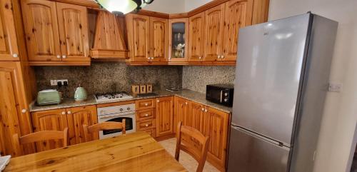 马尔萨斯卡拉Ramla Boutique Home的厨房配有木制橱柜和不锈钢冰箱。