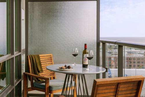 多伦多Sonder at The Liberty的阳台上的桌子和两杯葡萄酒