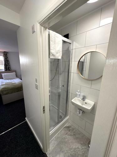 剑桥Newmarket Road Studios and Suites By Tas Accommodations的带淋浴、盥洗盆和镜子的浴室