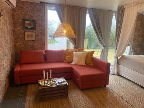 巴斯塔德Pia’s Country House的客厅,窗户前设有红色沙发