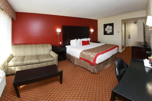 弗雷斯诺弗雷斯诺大学华美达酒店的酒店客房,配有床和沙发