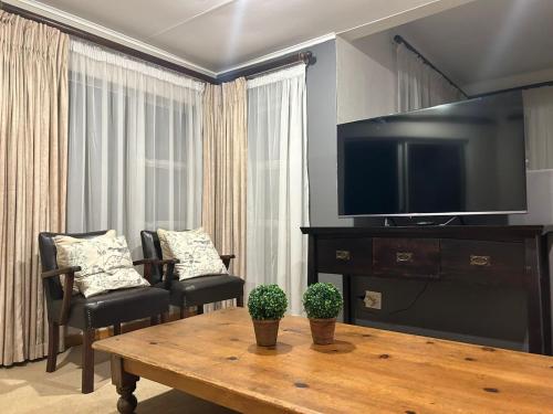 比勒陀利亚741 Tetra Self Catering Accommodation的客厅配有电视和桌椅