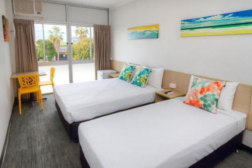 黄金海岸棕榈滩酒店的酒店客房设有两张床和窗户。