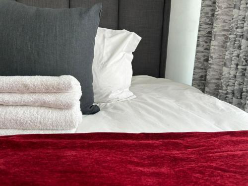 约翰内斯堡Lilly's Gold的一张带白色床单和红色毯子的床