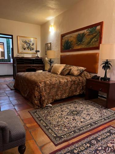 瓜达拉哈拉Casa Tlaquepaque的一间卧室配有一张大床和一架钢琴