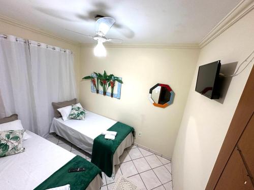 安格拉杜斯雷斯Quarto Ponta Negra的客房设有两张床和一台平面电视。