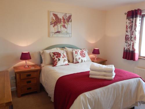 GolantChurch Meadow的一间卧室配有一张带红毯的床和两盏灯。