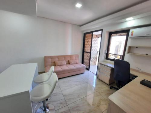 圣保罗Flat Apart-hotel QI Ibirapuera Perto do Shoping的客厅配有粉红色的沙发和书桌