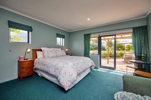 凯库拉Awatea Country Bed & Breakfast的一间卧室设有一张床和一个滑动玻璃门