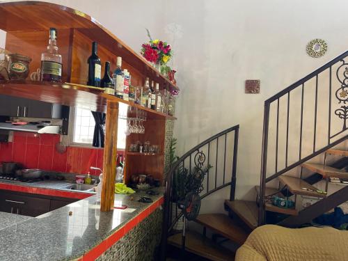 Casa para los 4 días de carnavales en Chitré的厨房配有水槽和带葡萄酒瓶的吧台
