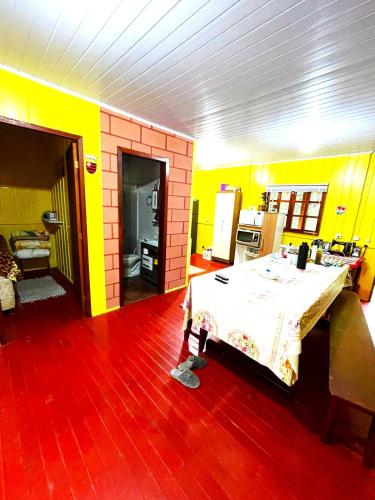 兰舒凯马杜Sítio Nature的一间设有桌子和黄色墙壁的房间
