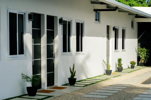 Santa ElenaCasa Valencia 2的白色的建筑,有黑窗和盆栽植物