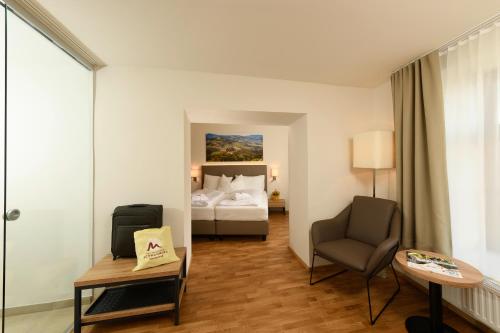 Schwanberg施万贝格海尔莫尔巴特酒店的配有一张床和一把椅子的酒店客房
