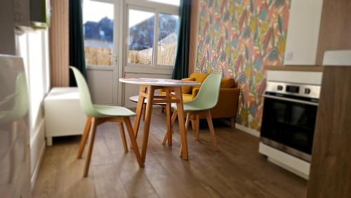 Thury-HarcourtNid douillet en Suisse Normande的带窗户的厨房里的桌椅