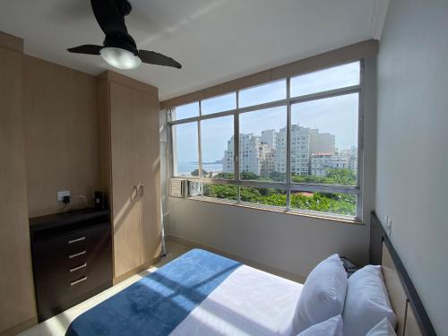 里约热内卢Loft Praia de Copacabana的一间卧室设有一张床和一个大窗户