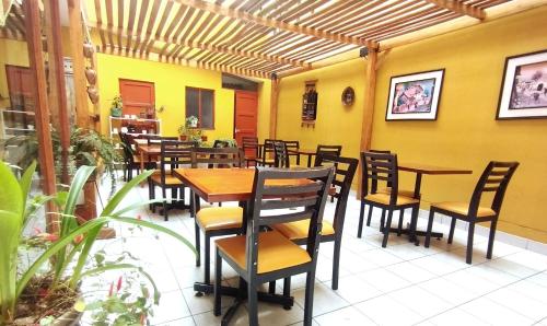 阿亚库乔Hotel Yañez Inn的一间设有木桌和椅子的餐厅