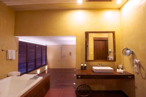 尼甘布杰特威塔拉赫纳别墅酒店的带浴缸、水槽和镜子的浴室